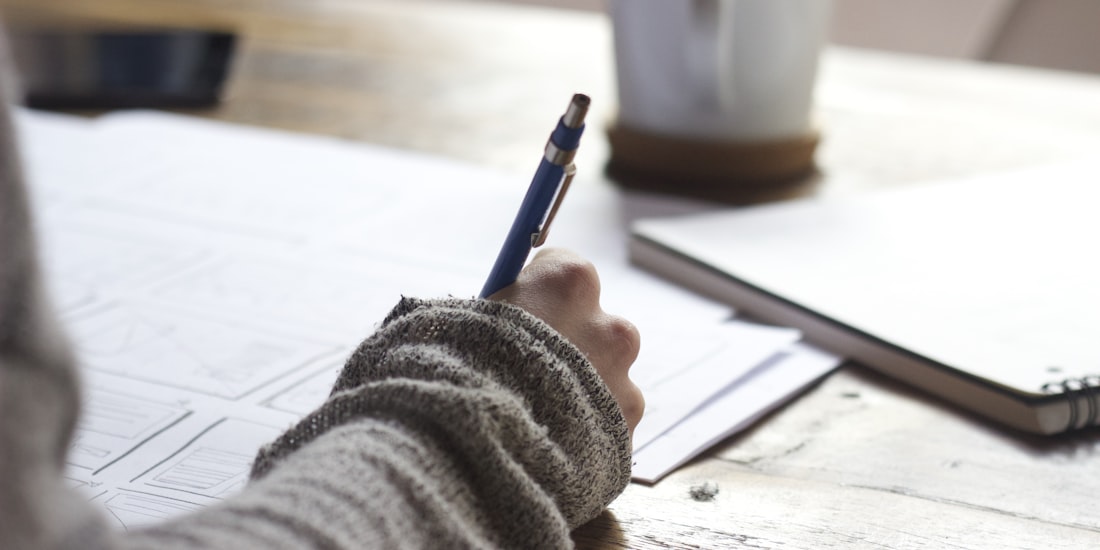 Estudiante escribiendo y organizando ideas para su investigación