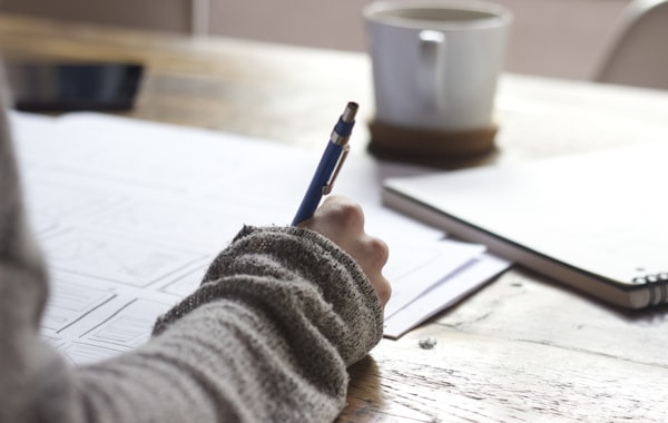 Estudiante escribiendo y organizando ideas para su investigación